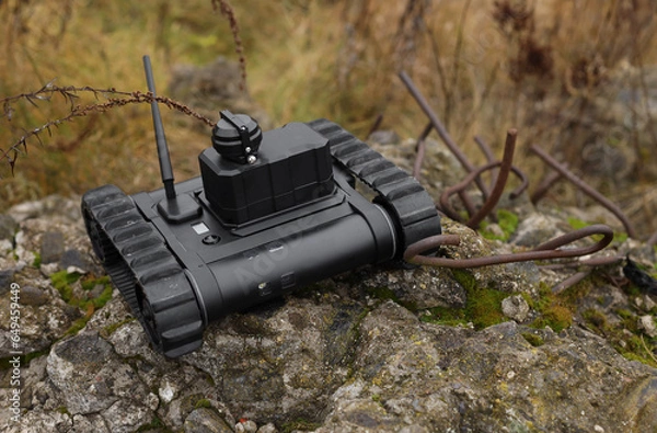 Fototapeta ground robot. in a field on a contaminated territory. Search and rescue robot with tracks.