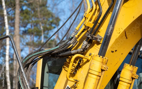 Obraz Closeup of the hydraulics hoses, pipes, fittings and cylinders on a working excavator machine.
