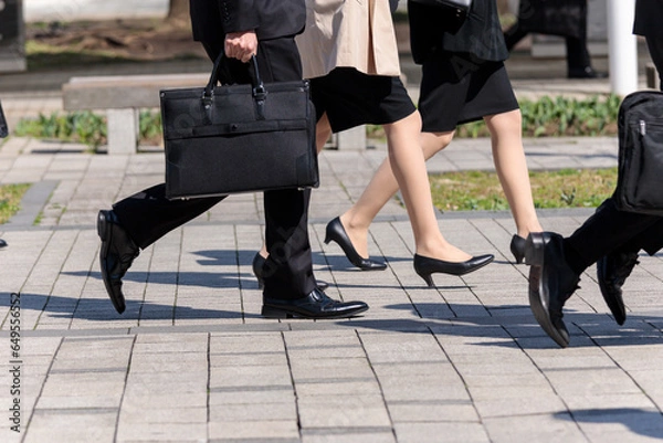 Fototapeta ビジネスバックを持って歩くビジネスマンの横向きの姿