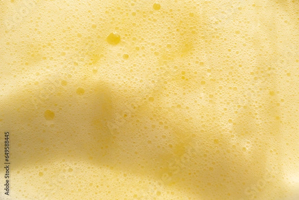 Obraz yellow bubbles of fruit drinks froth. Above view.