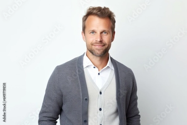 Fototapeta portrait of a confident Polish man in his 30s wearing a chic cardigan against a white background
