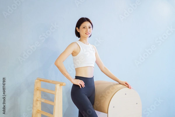 Obraz ピラティスインストラクター 日本人女性がラダーバレルでポーズ