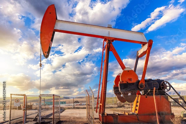 Fototapeta Pumpjack in the oil well of the oil field. Arrangement is commonly used for onshore wells producing little oil. It is overground drive for a reciprocating piston pump in an oil well.