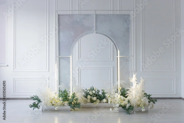 Fototapeta White arch with candlestick and floral arrangements in the interior