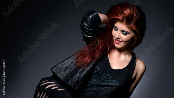 Obraz Beautiful redhead in black leather clothes isolated over gray