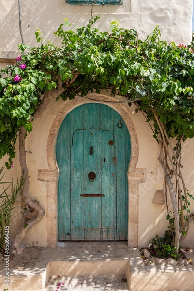 Obraz A traditional door with pattern and tiles, Hara Sghira Er Riadh - Djerbahood in Tunisia