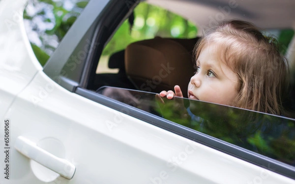Fototapeta Cute  little child looks out the window