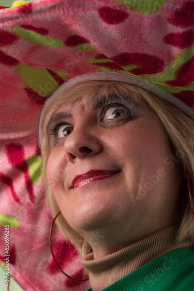 Obraz Clown in a hat. The buffoon grimaces and entertains. Portrait of a dressed up artist.