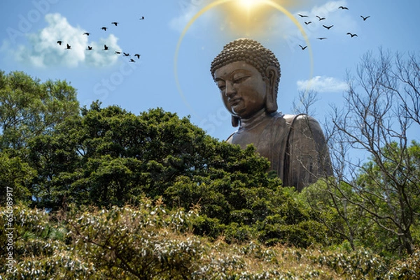 Fototapeta The Tian Tan Buddha in Hong Kong, surrounded by many flying birds, with a golden halo of light above the statue