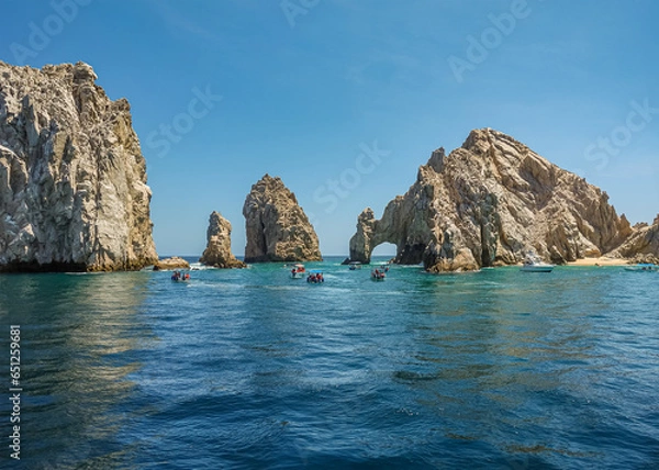 Fototapeta Mexico, Cabo San Lucas - July 16, 2023: El Arco rocky arch at Reserva de Lobos Marinos. Passage from ocean to bay with plenty of small sightseeing boats up front