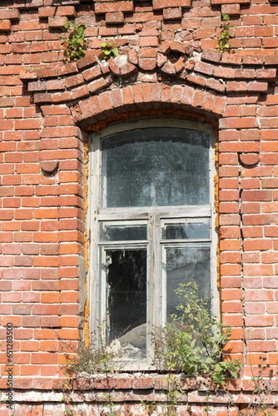 Fototapeta Window of an old red brick building in the village of Stolptsy, Ryazan region. Building near the ruins of a former needle factory built in 1718