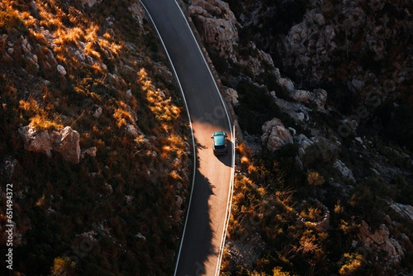 Obraz Aerial view of a car traveling across a scenic highway. Roadtrip during the autumn season