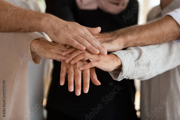 Fototapeta Like-minded people, business partners associates stacked palms together, touch hands feeling unity showing companionship, close up. Symbol of gender equality, shared success, loyalty, support concept