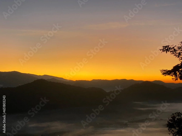 Obraz Sunrise behind mountain in the morning with magnificent mist landscape in winter season.