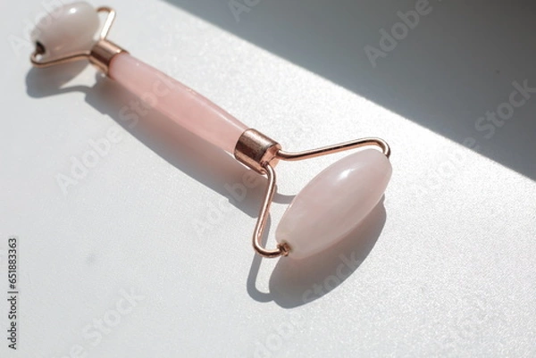 Obraz Pink face roller on white background with shades.