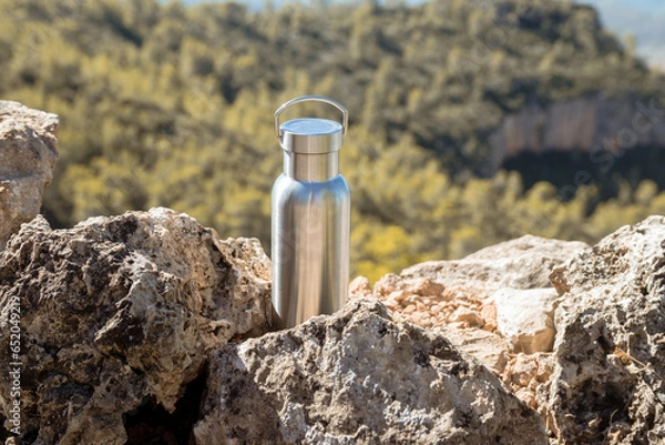 Obraz Thermal bottle on a rock on top of a mountain
