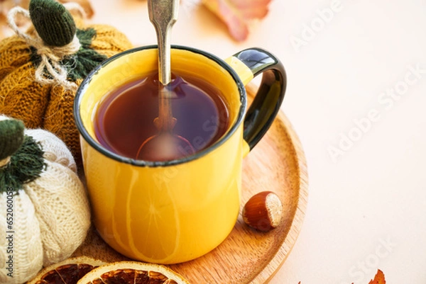 Fototapeta Cup of tea, spices, dry leaves, and knitted autumn decorations. Cozy autumn composition.