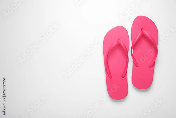 Fototapeta Stylish pink flip flops on white background, top view. Space for text