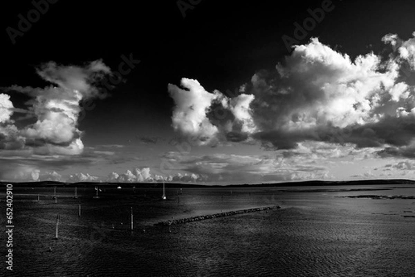 Fototapeta dramatic clouds over the sea in black and white