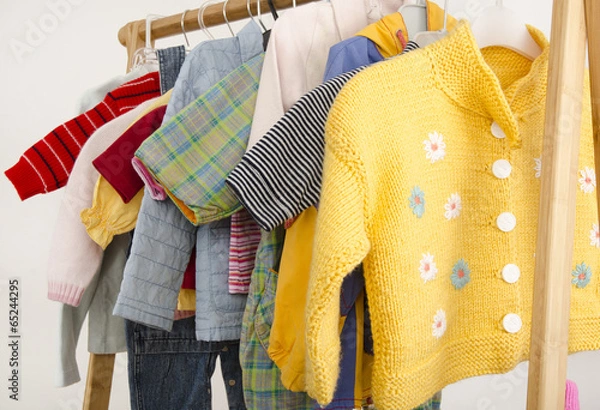 Fototapeta Wardrobe of newborn with clothes arranged on hangers toys