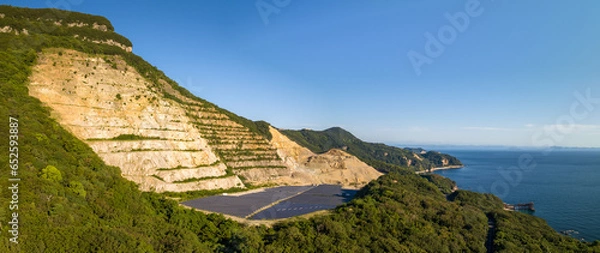 Fototapeta Exposed rock and solar panels at mountain quarry on Shodoshima coast