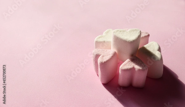 Fototapeta Delicate pink and white marshmallows in the shape of a heart on a pink background with copy space, banner. Marshmallow sweets closeup on a light background. Valentine's Day symbols tender marshmallow.