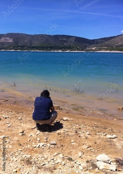 Obraz A man crouching making a photo