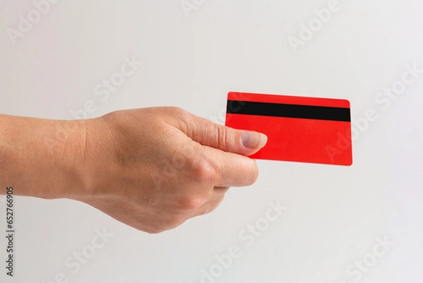 Fototapeta hand holds a bank card. Close-up