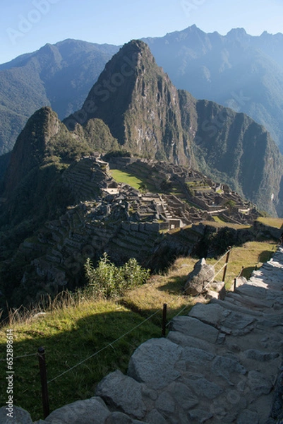 Fototapeta Panorama of Machupicchu with view of the mountains and archeological site, along with a stone staircase to the ruins, in Peru, Sacred Valley. 