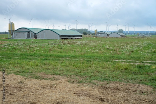 Obraz farm in the countryside with wind turbines in the background