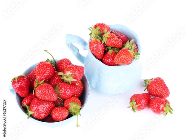 Fototapeta Ripe sweet strawberries in color mugs isolated on white