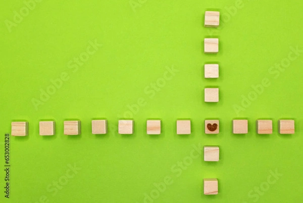 Fototapeta 黄緑の背景にウッドキューブのハートマークを中心にクロスさせたフレーム