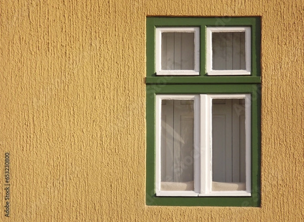 Obraz A window with a green frame on a yellow background.
