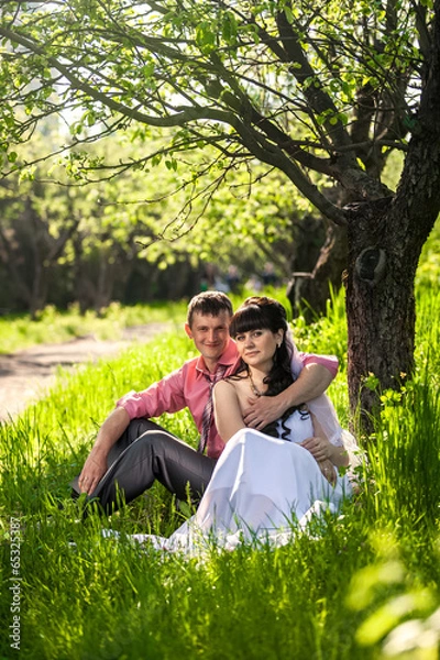 Fototapeta newly married couple hugging under tree at alley