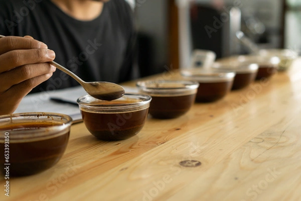 Fototapeta Coffee beans roasting process. the process of cupping black espresso Americano coffee which has gone through roasting, quality control and brewing processes
