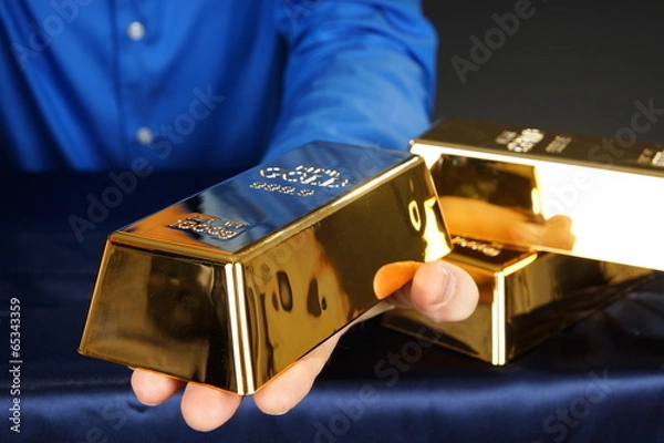 Fototapeta Businessman holds at hands gold brick