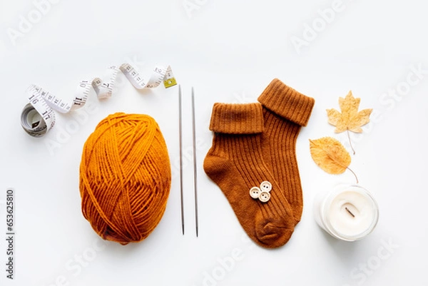 Obraz Set for knitting children's socks. Orange threads, knitting needles, buttons, centimeter.