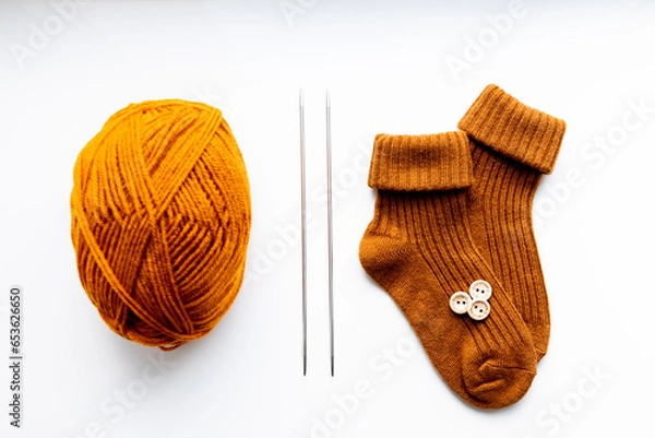 Obraz Set for knitting children's socks. Orange threads, knitting needles, buttons, centimeter.