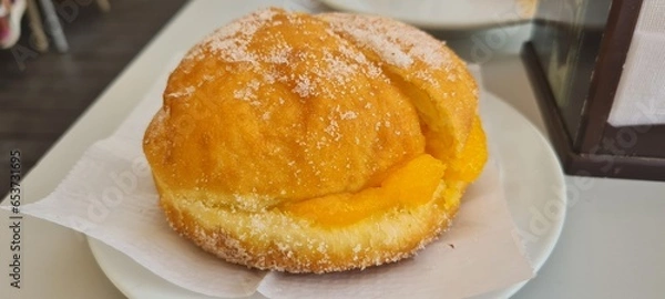Fototapeta A cream-filled pastry, known as a "bomba de crema", displayed for dessert.