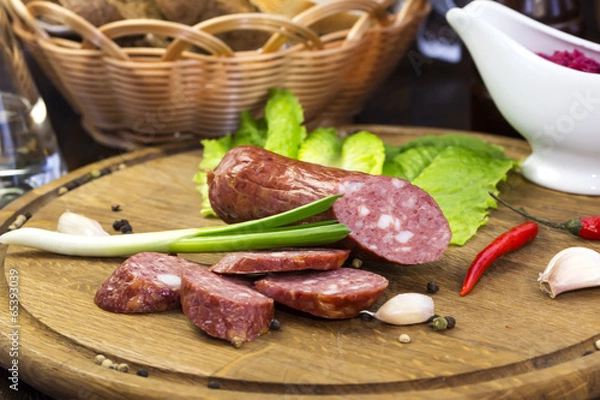Fototapeta sausage on a wooden plate in a restaurant
