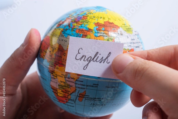 Fototapeta Hand holding notepaper with English wording on globe