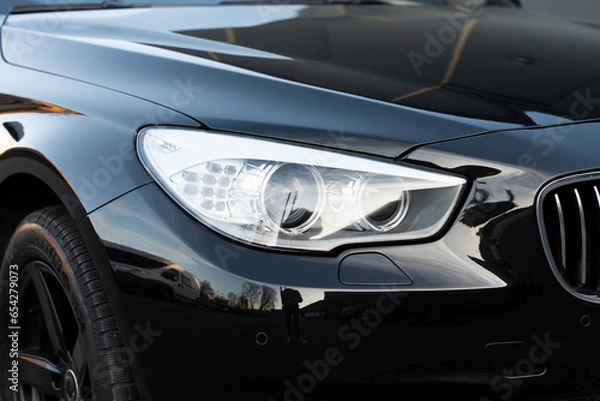 Obraz Black luxury automobile with white headlights and chrome grille on bumper. Led elements for day and night lightning in exterior of new auto