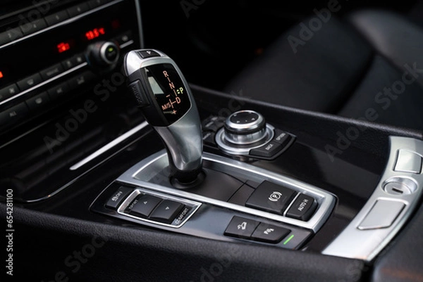 Fototapeta Automatic gearbox handle, multimedia dashboard and leather interior of high-end modern car. Close up of deluxe vehicle attributes.