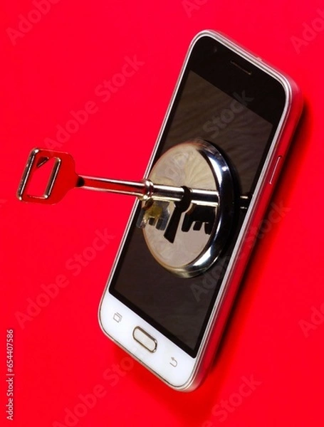 Fototapeta Smartphone data security. The key and the keyhole on the smartphone screen on a red background.