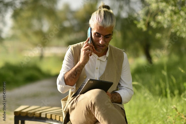 Obraz Businessman doing business analysis and evaluation by phone.