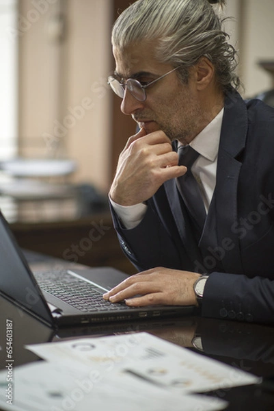 Fototapeta Business person talking on the phone, having a job interview, doing analysis with a tablet, and doing a job evaluation with a laptop.