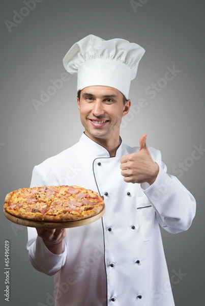 Fototapeta Smiling chef with fresh pizza showing thumbs up