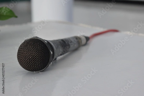 Fototapeta photo of a microphone lying on a white table