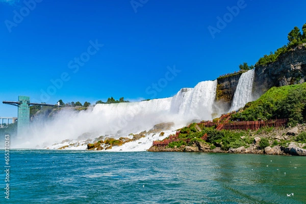 Fototapeta View on the Bridal Veil Falls and American Falls of the Niagara Falls, the part of Goat Island, the Cave of the Winds Lookout, stairs and platforms, wooden walkways, Niagara Falls, New York, USA High