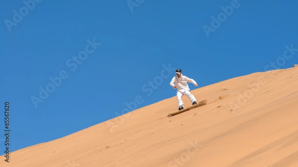 Obraz Man sandboarding in Namibia